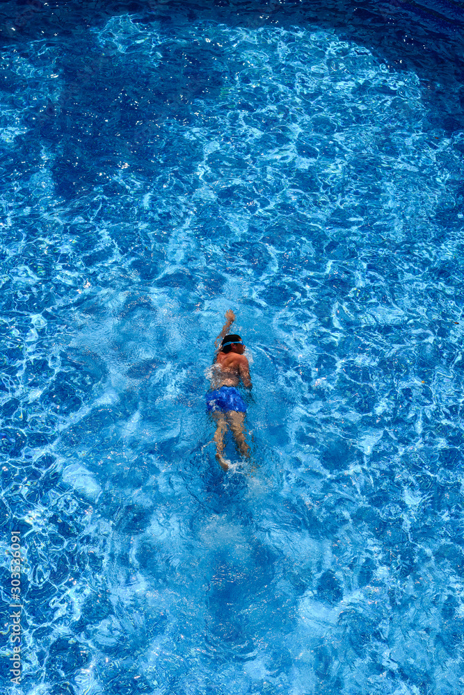 Fototapeta premium Top view of a man in swimming pool