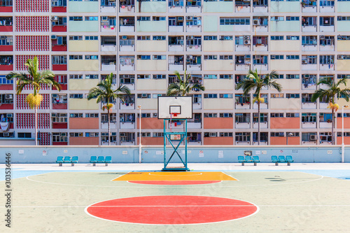 Empty basketball court with colorful building on the back.