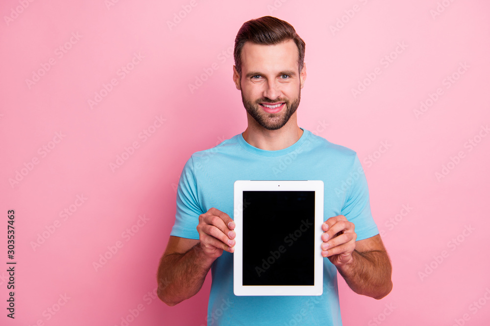 Photo of cheerful positive cheerful man smiling toothily holding tablet demomstrating you its perfect screen isolated pastel color background Photo of cheerful positive cheerful man smiling toothily holding tablet demomstrating you its perfect screen isolated pastel color background