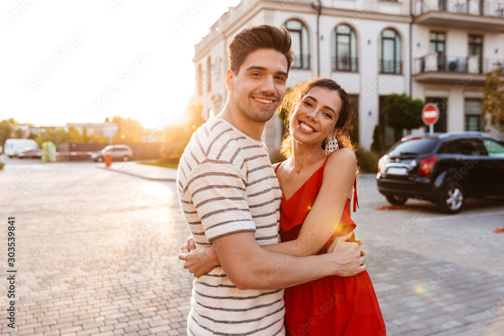 Image of happy caucasian couple smiling and hugging