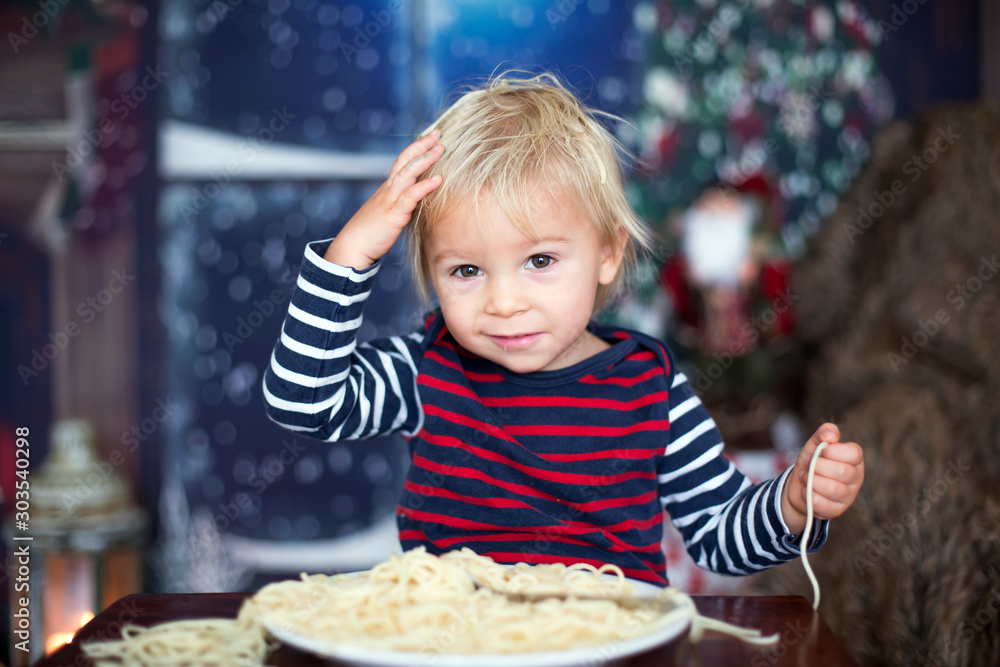 Sweet toddler child, boy, eating spaghetti at home Sweet toddler child, boy, eating spaghetti at home