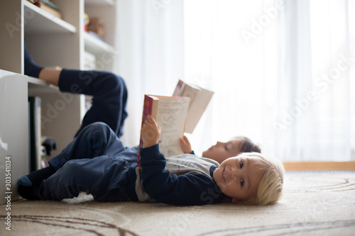 Cute child, boy, reading a book at home