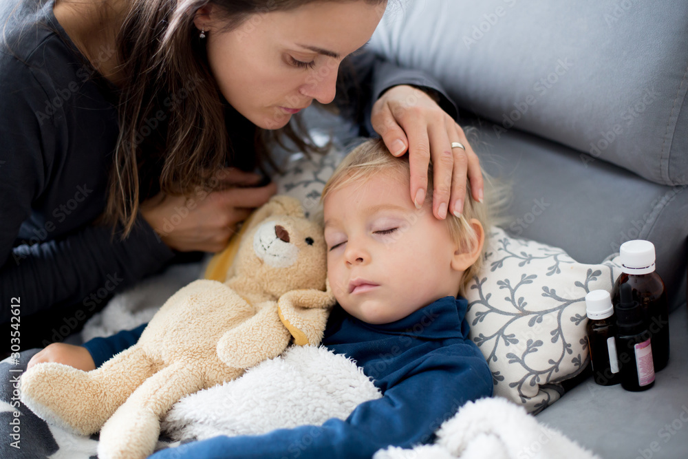 Blond toddler boy, sleeping on the couch in living room, lying down with fever Blond toddler boy, sleeping on the couch in living room, lying down with fever
