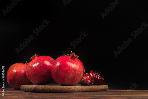 Ripe pomegranate fruit on wooden vintage background. - Image