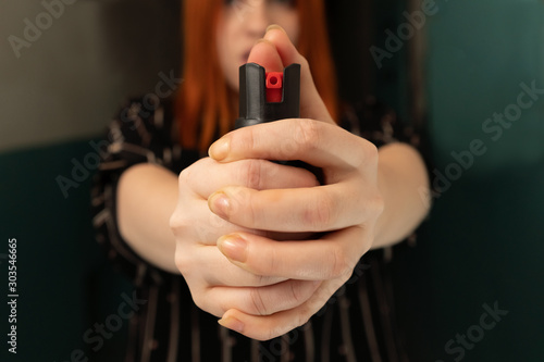 Girl hand is protected by pepper spray. Self defense concept