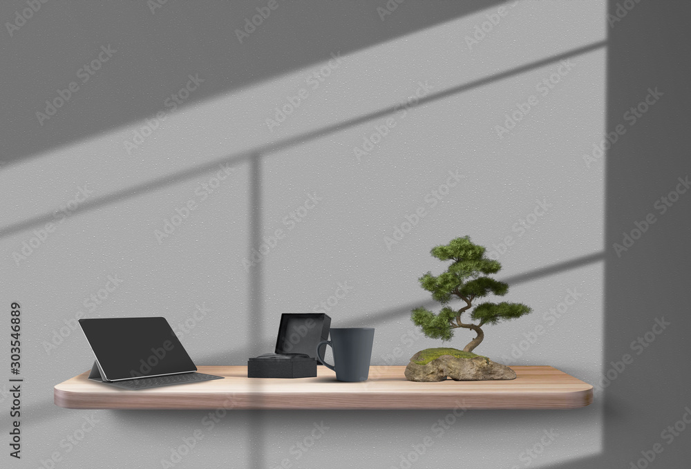 Tablet, gift box, cup and bonsai tree on a wooden shelf, suspended from the gray wall, shadows from the window on it. Mockup. Close-up. Tablet, gift box, cup and bonsai tree on a wooden shelf, suspended from the gray wall, shadows from the window on it. Mockup. Close-up.