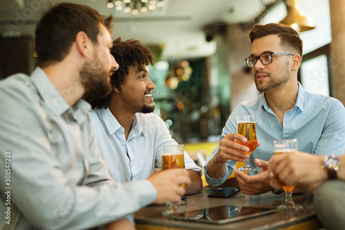 Four businessmen drink beer after work. Businessmen enjoy a beer.