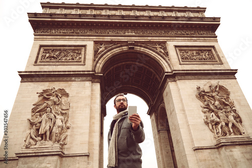 Handsome man using cellphone while enjoying in Paris. © Kitja