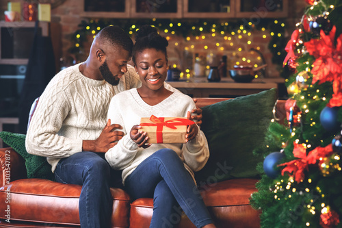 Loving black boyfriend giving Christmas present to his girlfriend