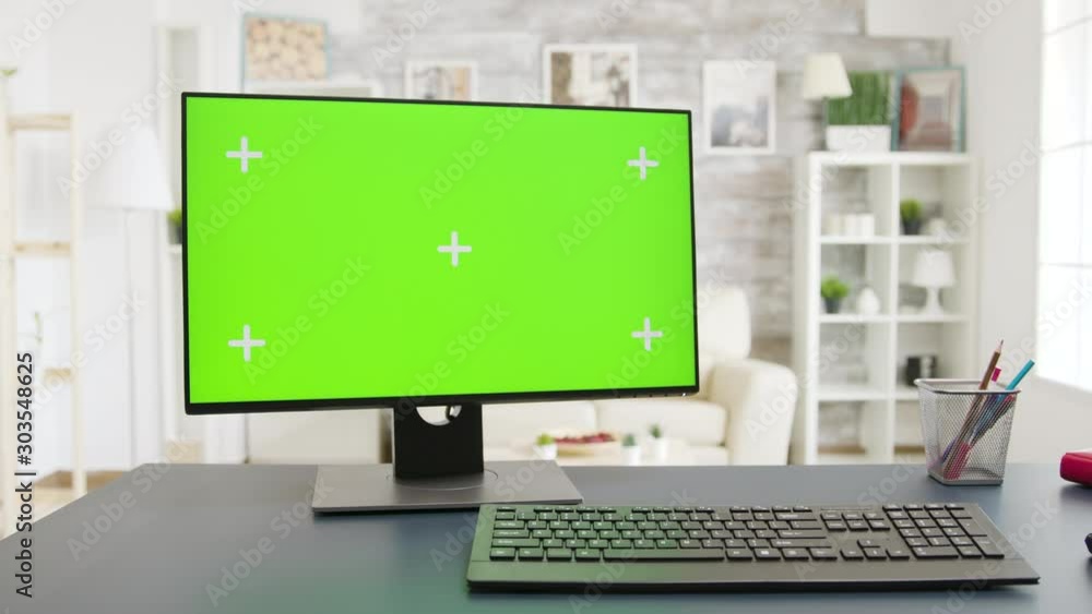 Display with green screen in cozy and well lit living room Display with green screen in cozy and well lit living room