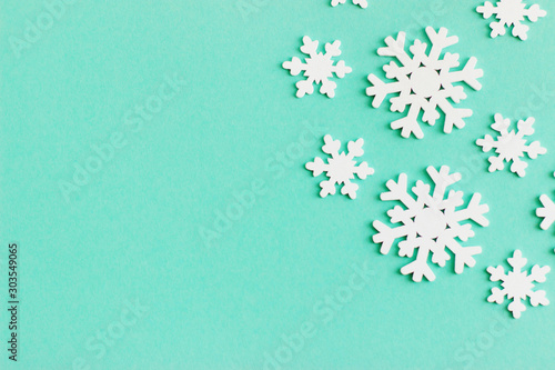 Wooden white snowflakes on mint background.