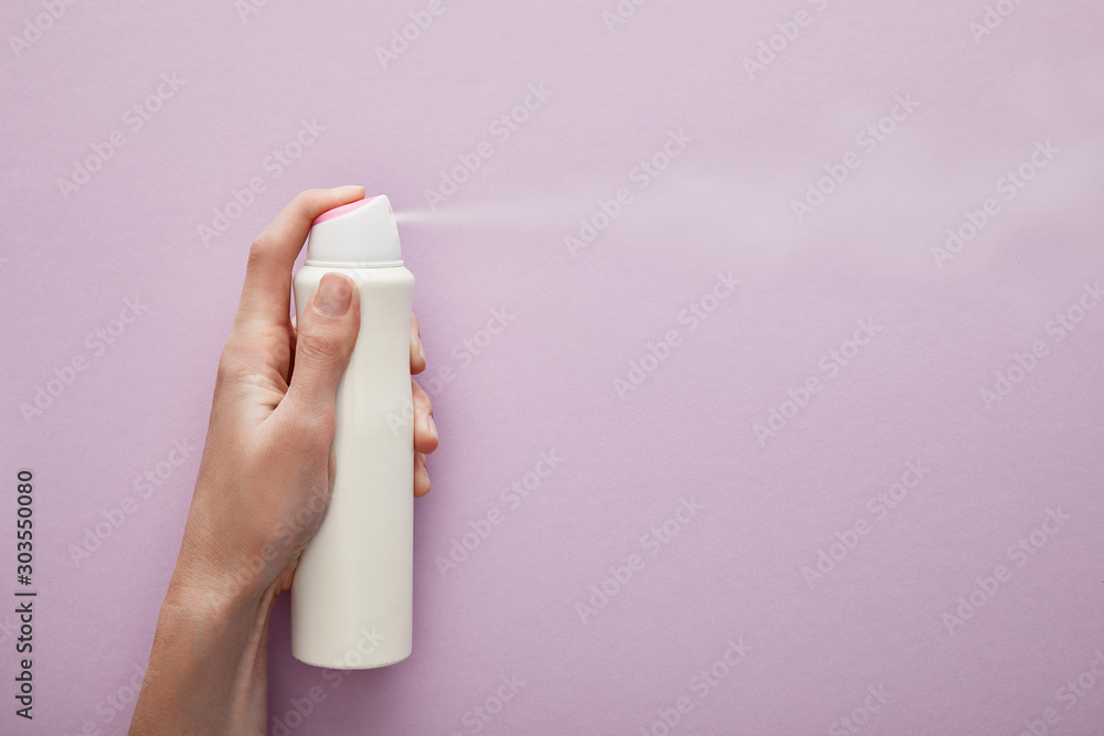 Ταπετσαρία cropped view of woman spraying deodorant on violet background with white roses