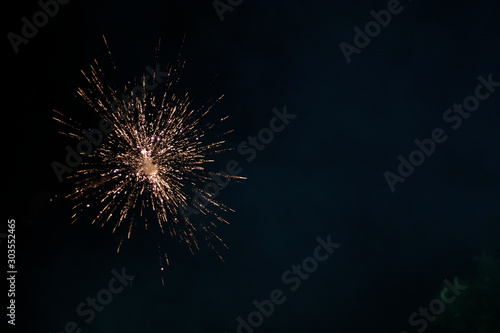 The sparkling burst of festive firecracker sky shot at night gives an impression of some cosmic phenomenon. Its dark black background with space for text is good for presentation related to festivals.