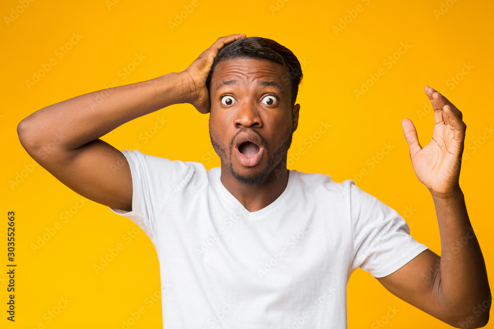 Amazed Man Standing Clutching Head Looking At Camera, Studio Shot Amazed Man Standing Clutching Head Looking At Camera, Studio Shot