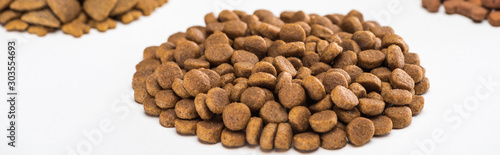 selective focus of fresh dry pet food in pile isolated on white, panoramic shot