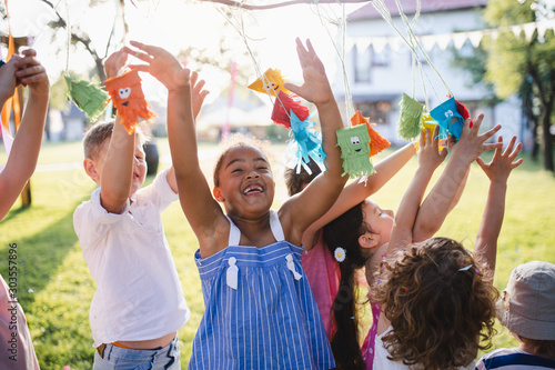 Small children standing outdoors in garden in summer, playing.