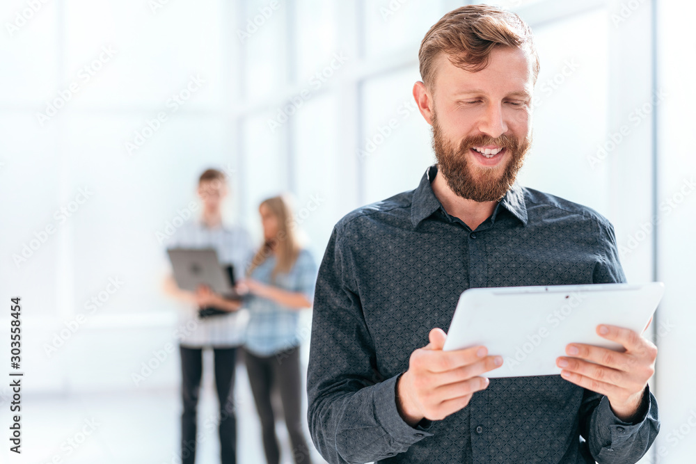 smiling businessman looking at the screen of his digital tablet smiling businessman looking at the screen of his digital tablet