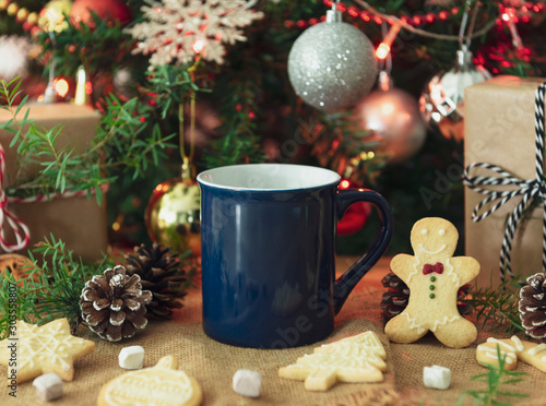 Blue ceramic coffee cup and christmas decoration on woon table background. mockup for creative advertising text message or promotional content. photo