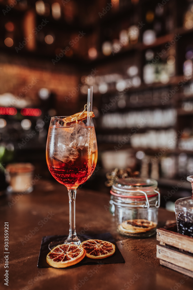 A glass of Aperol cocktail on a bar. Concept of summer drinks and hospitality. Classic summer drink from Northern Italy.