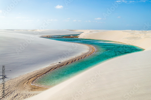 Fototapeta Naklejka Na Ścianę i Meble -  A beautiful turquoise river flowing through white dunes in Brazil