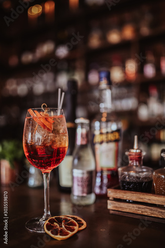 London, UK. 16.05.2017 A close up shot of Aperol Spritz cocktail with a bottle of Aperol behind it. Classic alcoholic cocktail from Northern Italy. Concept of hospitality and summer drinks. © Olga