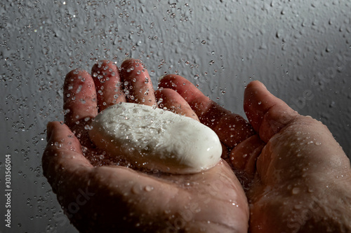 Soap in human hands and falling water.