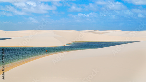 A stream of water flowing through white dunes in Brazil