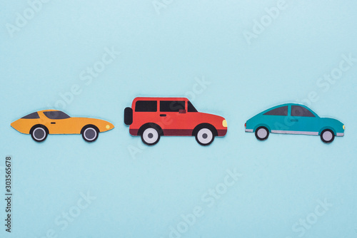 Fototapeta Naklejka Na Ścianę i Meble -  top view of paper cut various cars on blue background