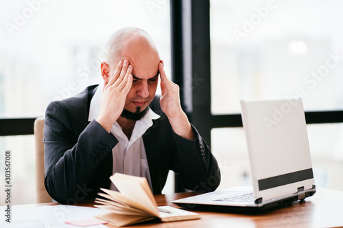 Fatigue, lack of concentration, headache, stressful work. Tired businessman at his workplace.