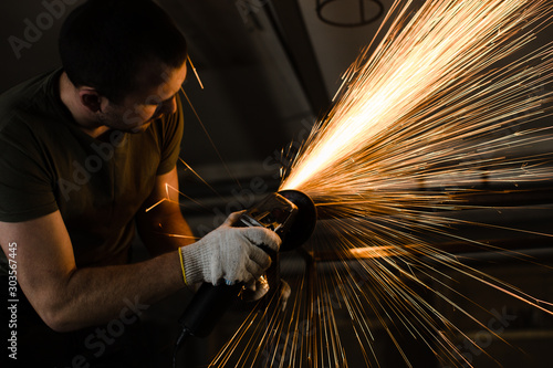 A man works with metal and sparks fly beautifully