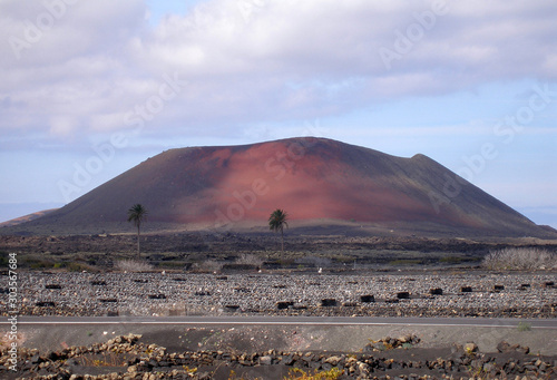 verschiedenfarbiger vulkankrater mit sonnenfleck im timanfaya nationalpark photo