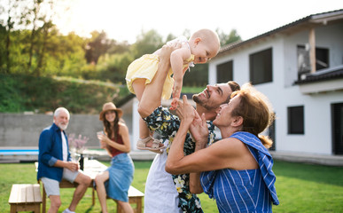 Portrait of multigeneration family outdoors on garden barbecue.