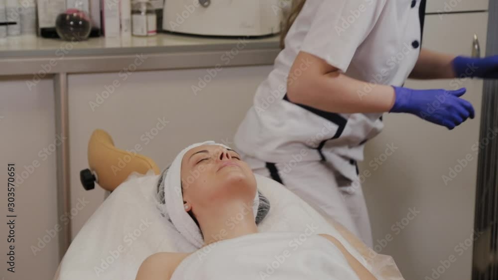 Professional beautician wipes woman face with wet wipes. Professional beautician wipes woman face with wet wipes.