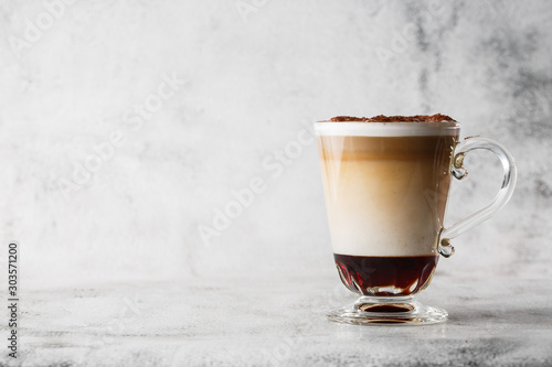 Coffee with Irish whiskey and whipped cream in glass isolated on bright marble background. Overhead view, copy space. Advertising for cafe menu. Coffee shop menu. Horizontal photo.