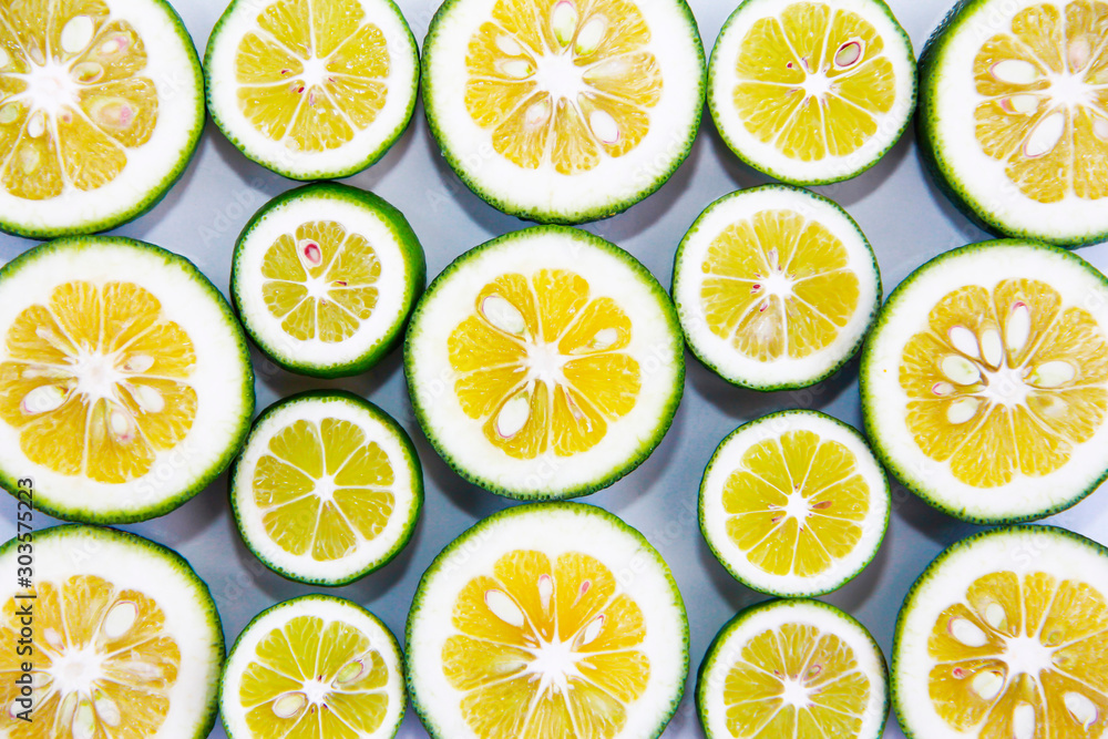 round slices of natural fresh yellow lemon in a green peel round slices of natural fresh yellow lemon in a green peel