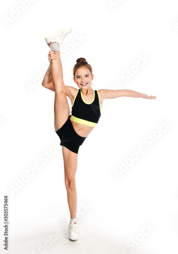 Flexible cute little girl child gymnast doing acrobatic exercise isolated on a white background