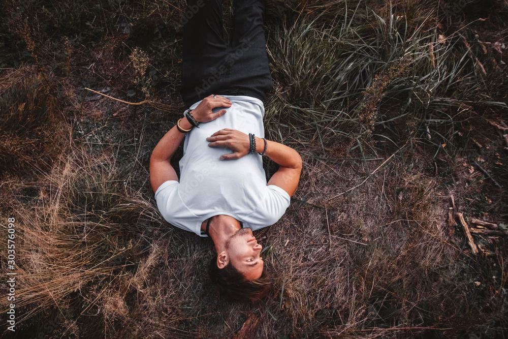 Ταπετσαρία Man lies on the grass in the middle of the forest relaxing - resting