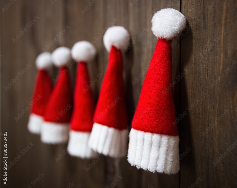 Little Santa Claus hats. Christmas tree toys handmade. Christmas Wooden background. Christmas ornaments.