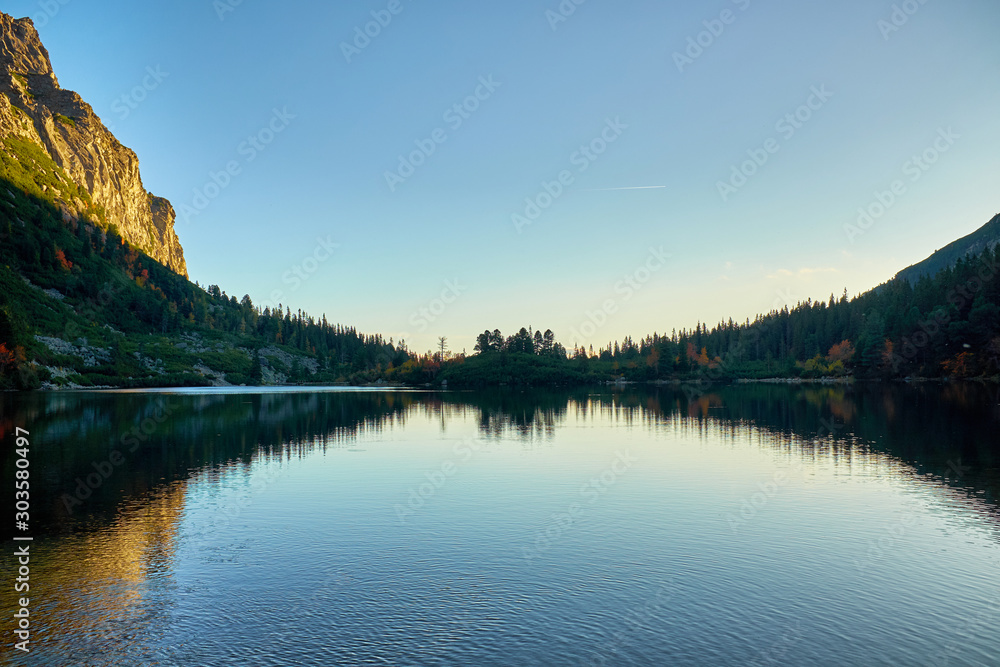 Poprad lake after sunset with refletion on silhouettes on water in High Tatras mountain National Park, Slovakia