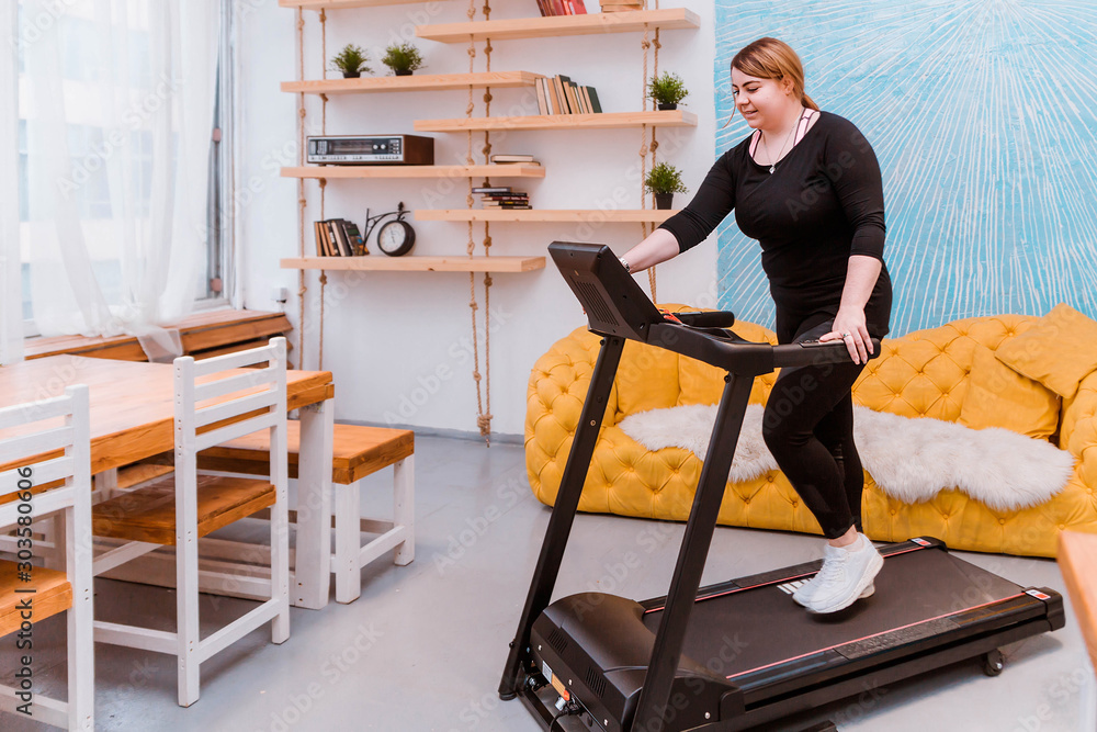 Φωτογραφία Model - a fat woman, trying to lose weight and at home engaged on a treadmill