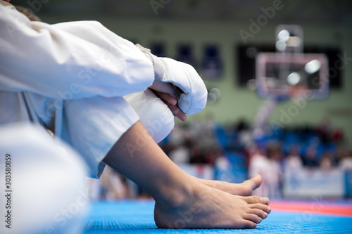 A child sits in karate competitions and is waiting for a fight photo