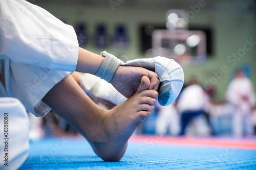 A child sits in karate competitions and is waiting for a fight