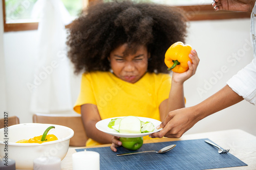mother and daughter eat fruit in kitchen