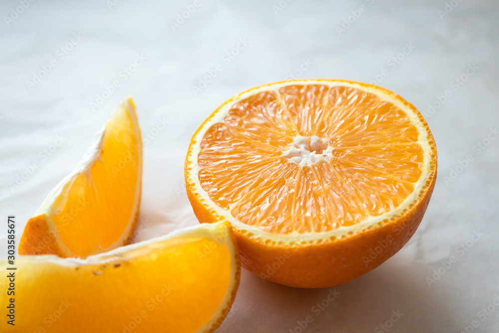 Close-up half of orange and slice on light table surface. Fresh citrus fruit, horizontal composition Close-up half of orange and slice on light table surface. Fresh citrus fruit, horizontal composition
