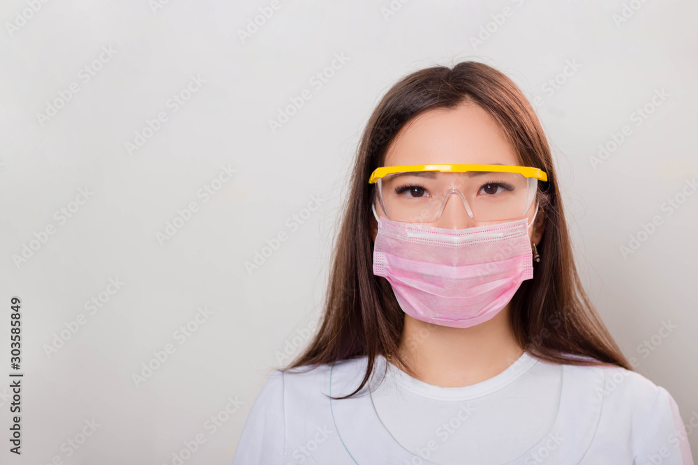 Portrait of a girl in a white coat, mask and glasses. Photo on a white background. Portrait of a girl in a white coat, mask and glasses. Photo on a white background.
