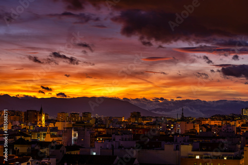 Sunset over Malaga, Spain - partly cloudy with yellow and red sky