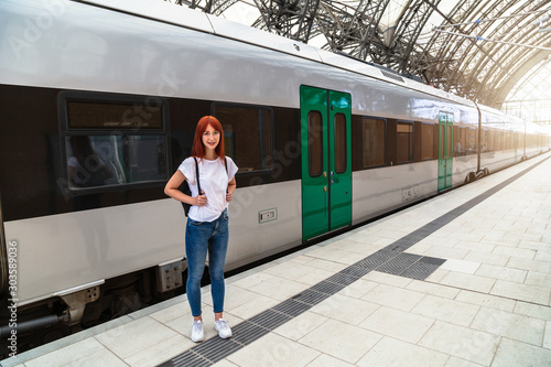 Girl posing on background of train on platform