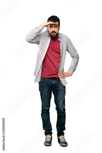 Cuadro en lienzo Full-length shot of Handsome man with beard looking far away with hand to look s