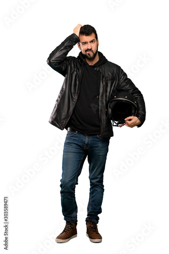 Full-length shot of Biker man with an expression of frustration and not understanding over isolated white background