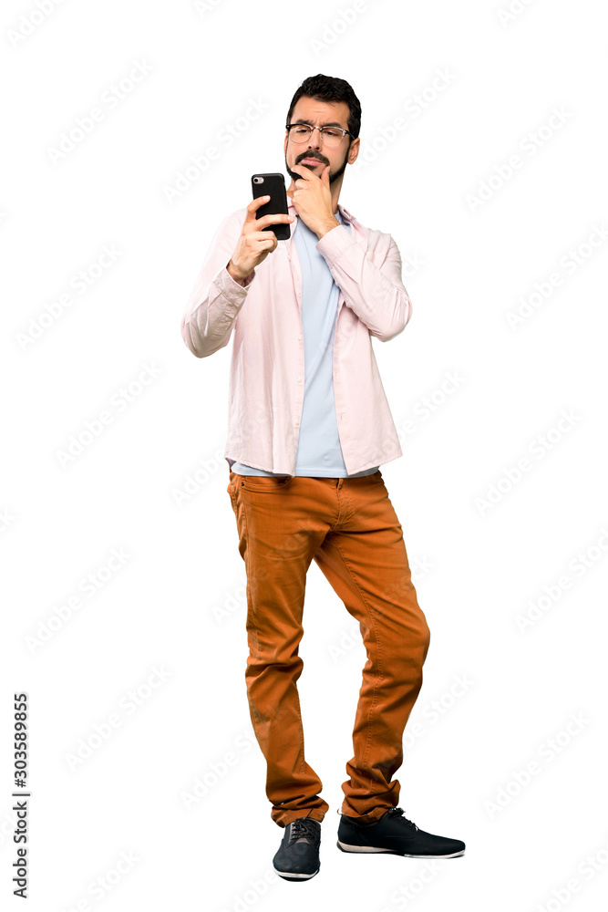 Full-length shot of Handsome man with beard thinking and sending a message over isolated white background Full-length shot of Handsome man with beard thinking and sending a message over isolated white background